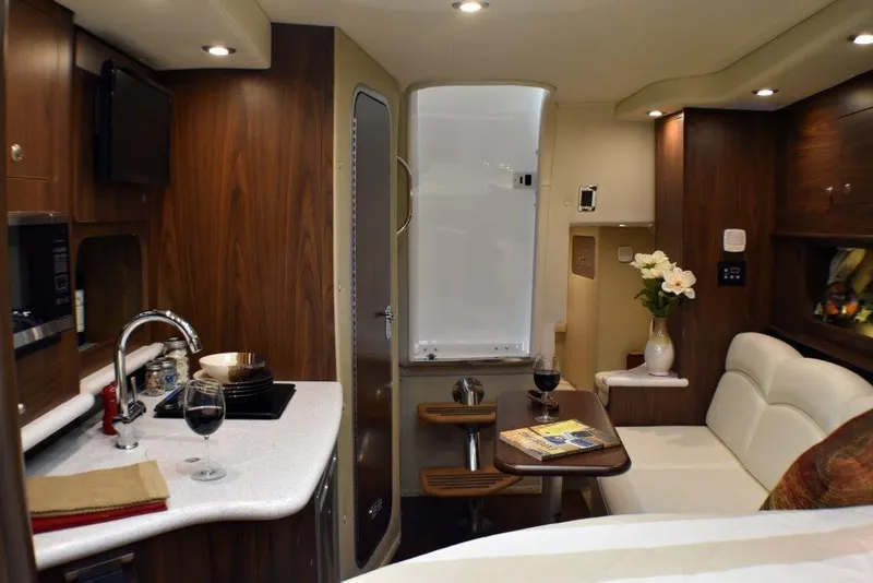 Slide: The Image of Manufacturer Provided Image: 2019 Rinker 320 EX interior with kitchenette, dining area, and modern amenities. - 14