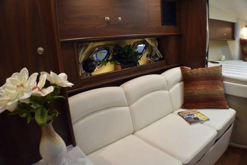 Slide: The Image of Manufacturer Provided Image: Interior of 2019 Rinker 320 EX boat with white leather sofa and decorative flowers. - 15