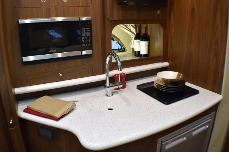 Slide: The Image of Manufacturer Provided Image: 2019 Rinker 320 EX boat kitchen with microwave, sink, and countertop. - 16