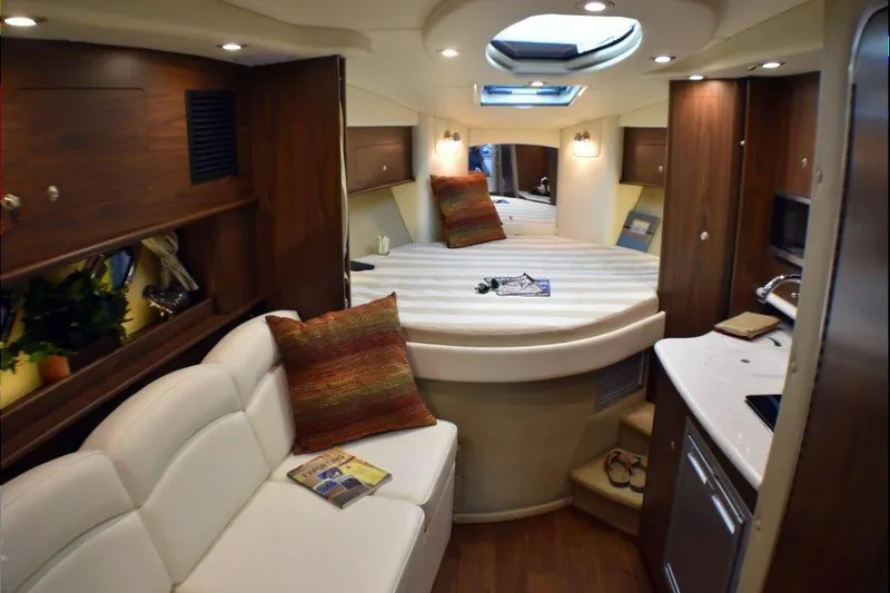 Slide: The Image of Manufacturer Provided Image: 2019 Rinker 320 EX cabin interior with bed, sofa, and kitchenette. - 17
