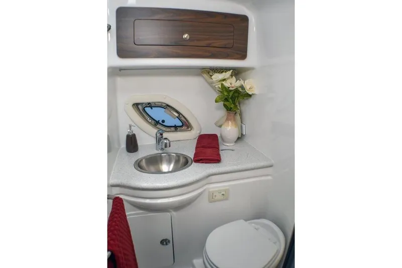 Slide: The Image of Manufacturer Provided Image: 2019 Rinker 320 EX boat bathroom with sink, toilet, and porthole window. - 20