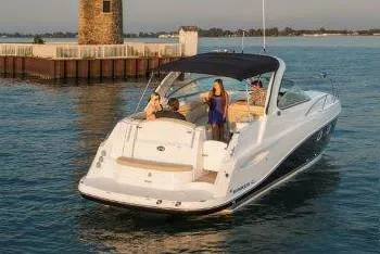 Slide: The Image of Manufacturer Provided Image: 2019 Rinker 320 EX boat cruising near a lighthouse with passengers on board. - 4