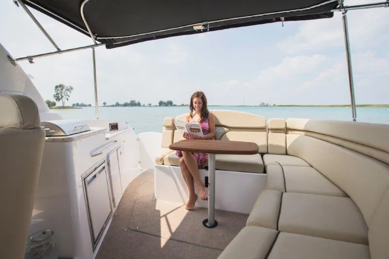 Slide: The Image of Manufacturer Provided Image: Woman relaxing on a 2019 Rinker 320 EX boat with spacious seating. - 6