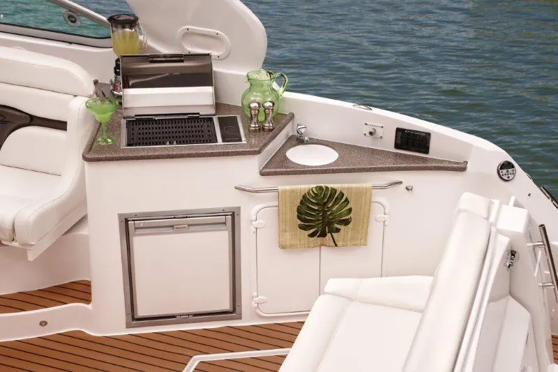 Slide: The Image of Manufacturer Provided Image: 2019 Rinker 320 EX boat interior with kitchenette and seating area. - 7