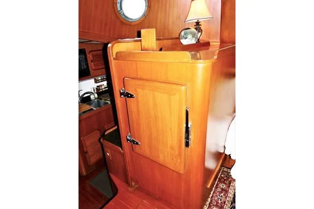 Slide: The Image of 1982 Ta Shing Mason 63 yacht interior with open wooden cabinet and visible storage. - 12