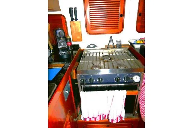 Slide: The Image of 1982 Ta Shing Mason 63 yacht interior with wooden cabinetry and black countertop. - 25