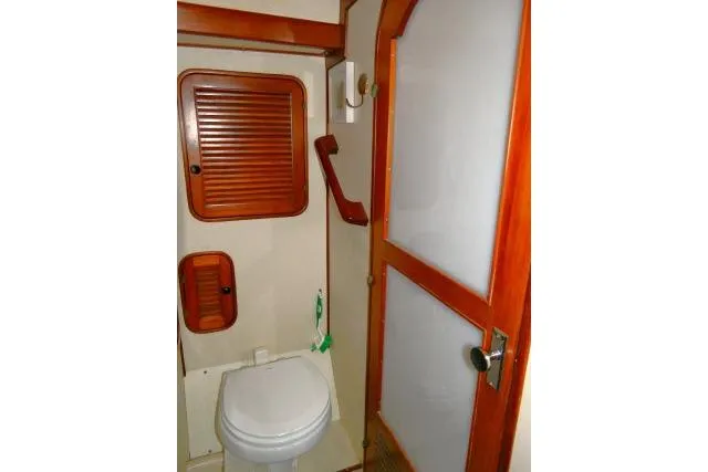 Slide: The Image of Interior of 1982 Ta Shing Mason 63 yacht, featuring a compact bathroom with wooden accents. - 50