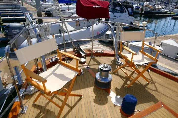 Slide: The Image of Deck of 1982 Ta Shing Mason 63 yacht with chairs labeled "S/V Aviner" at marina. - 63