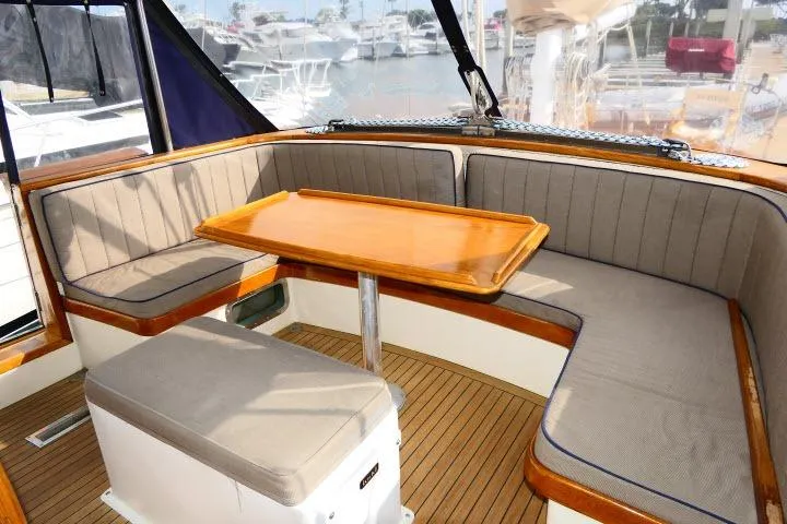 Slide: The Image of Elegant 1982 Ta Shing Mason 63 yacht interior with cushioned seating and wooden table. - 73