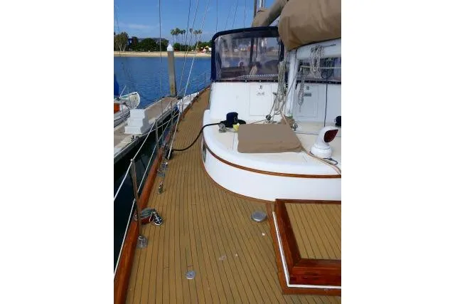 Slide: The Image of 1982 Ta Shing Mason 63 sailboat deck with wooden finish, docked at marina. - 78