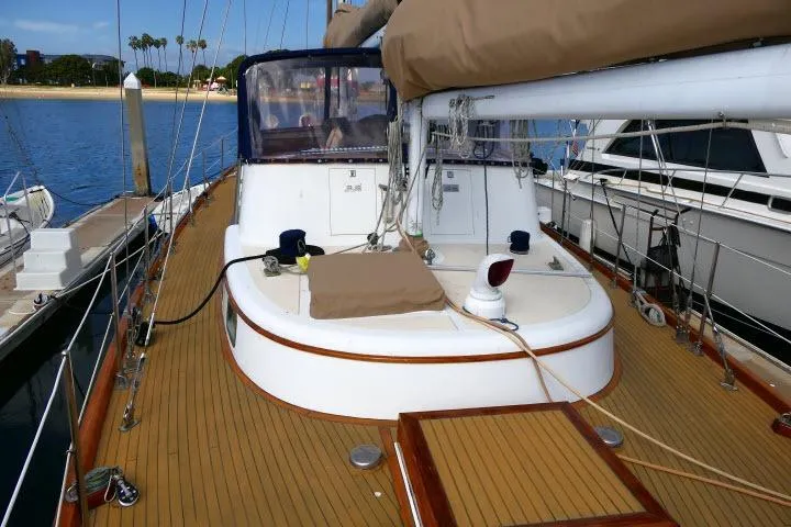 Slide: The Image of 1982 Ta Shing Mason 63 sailboat deck with wooden finish, docked by calm waters. - 79