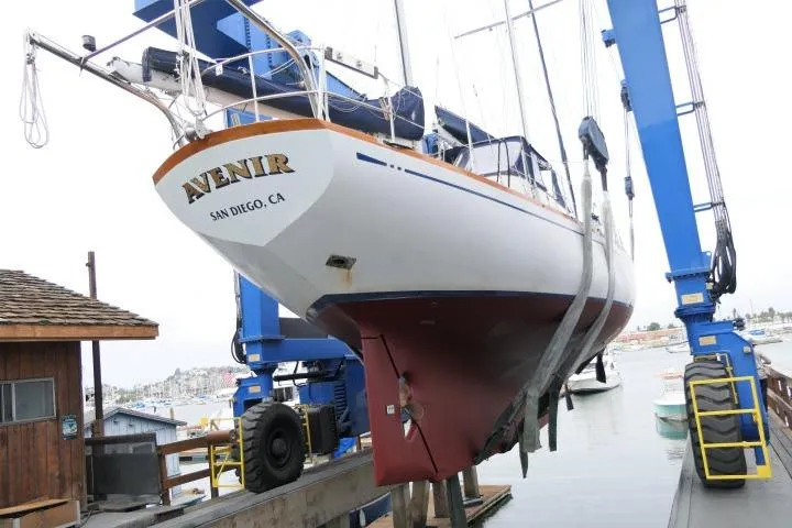 Slide: The Image of 1982 Ta Shing Mason 63 yacht hull in dry dock, showcasing red and blue paint. - 95