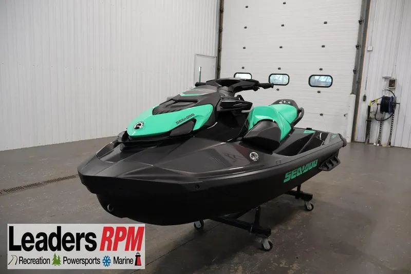 The Image of 2026 Sea-Doo GTI SE 130 jet ski in showroom, featuring sleek black and green design. - 0