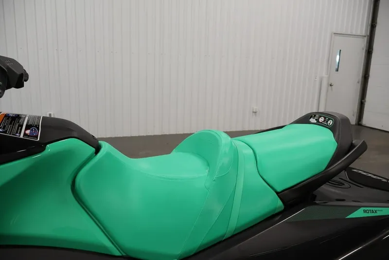 Slide: The Image of 2026 Sea-Doo GTI SE 130 jet ski with vibrant green seat in a showroom. - 18