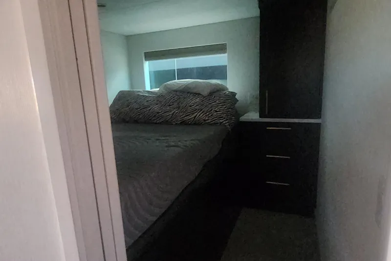 Slide: The Image of Cozy bedroom interior in Adonia Legacy Trip #15, featuring a bed and storage, 2022. - 16