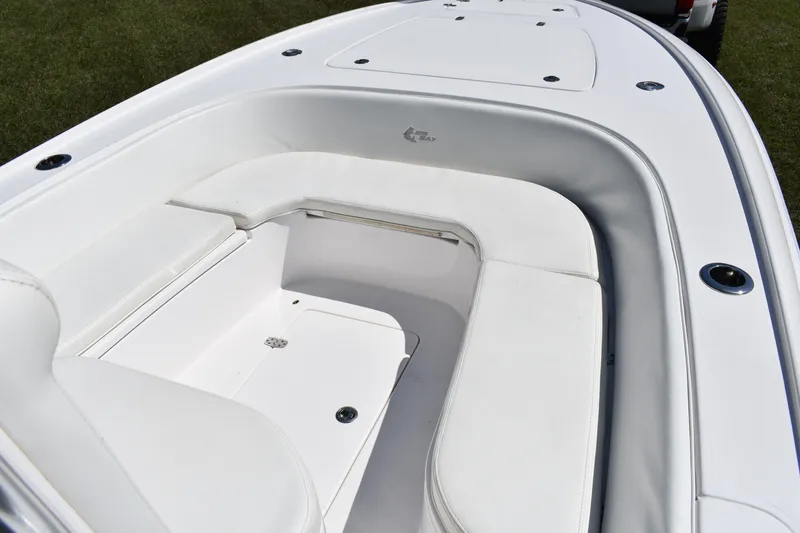 Slide: The Image of 2018 Contender 25 Bay boat interior with white cushioned seating and storage compartments. - 12