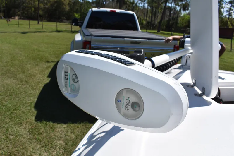 Slide: The Image of 2018 Contender 25 Bay with i-Pilot trolling motor, parked on grass near a truck. - 14