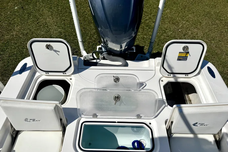 Slide: The Image of 2018 Contender 25 Bay boat with open storage compartments and engine, viewed from above. - 19