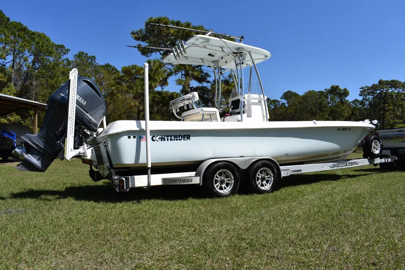 Slide: The Image of 2018 Contender 25 Bay boat on trailer, featuring Yamaha outboard motor, parked on grass. - 3
