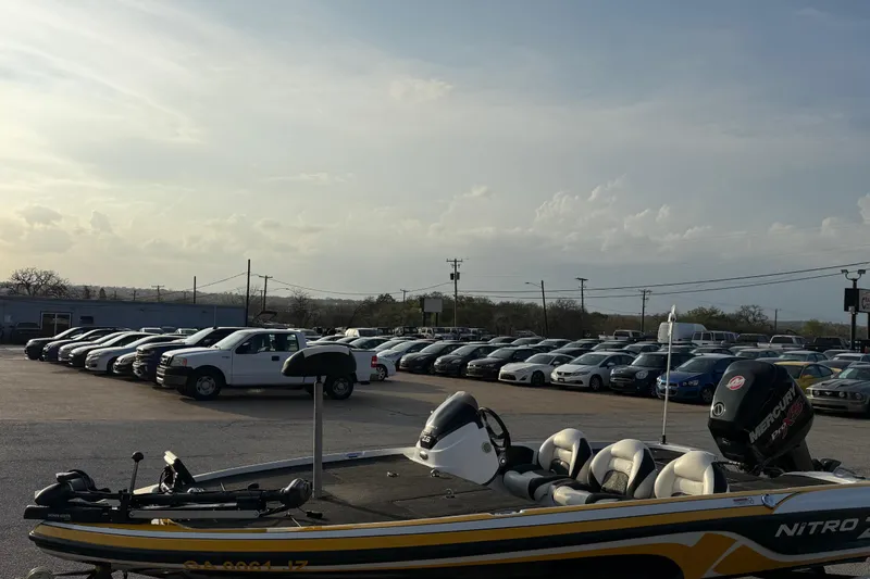 Slide: The Image of 2015 Nitro Z-6 boat in parking lot with cars under cloudy sky. - 14
