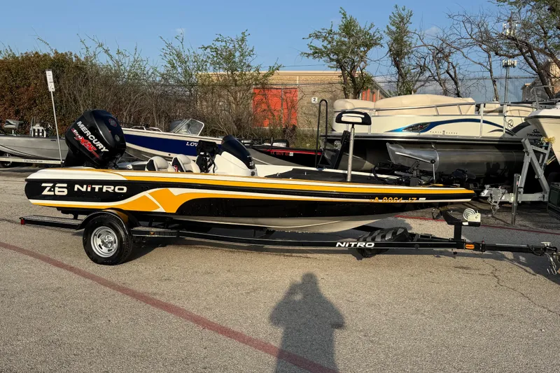 Slide: The Image of 2015 Nitro Z-6 boat with trailer, parked outdoors, featuring a Mercury engine. - 4