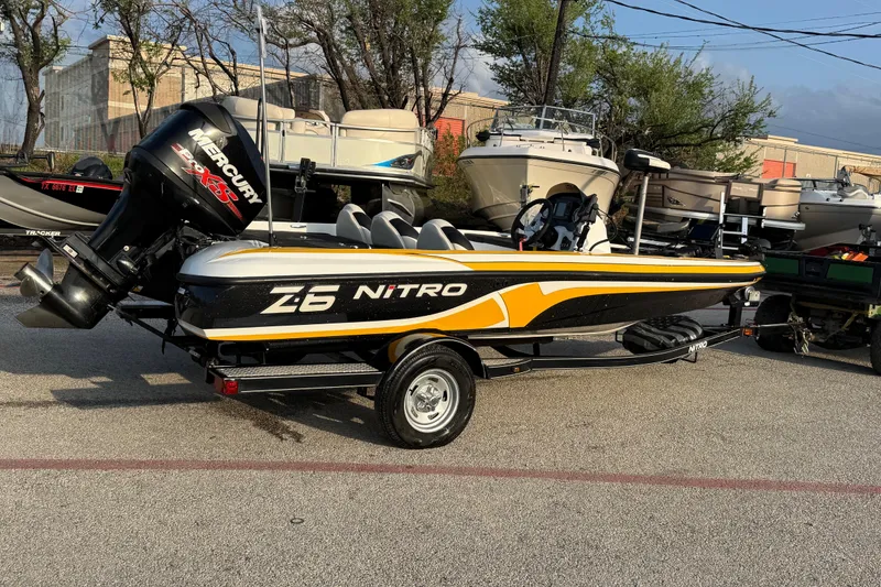 Slide: The Image of 2015 Nitro Z-6 boat with Mercury engine, parked on a trailer in a lot. - 8