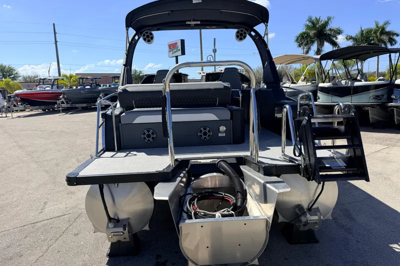 Slide: The Image of 2026 Avalon 2585 Excalibur LTD Tri Toon boat, rear view, in a sunny marina setting. - 8