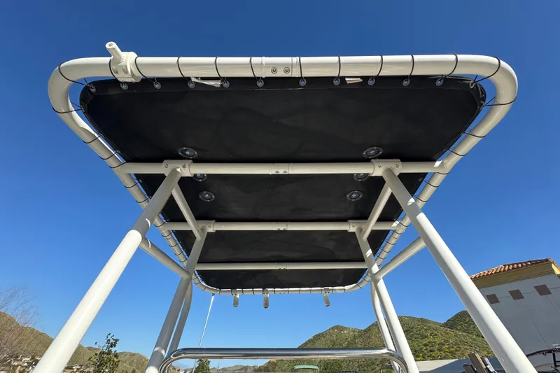Slide: The Image of Trophy T18 boat canopy, 2022 model, under clear blue sky with mountain backdrop. - 14
