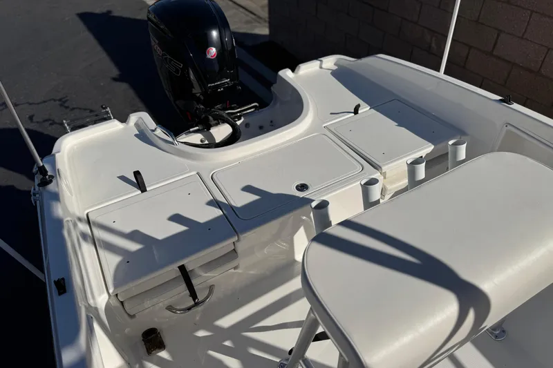 Slide: The Image of 2022 Trophy T18 boat interior with motor, storage compartments, and rod holders. - 19