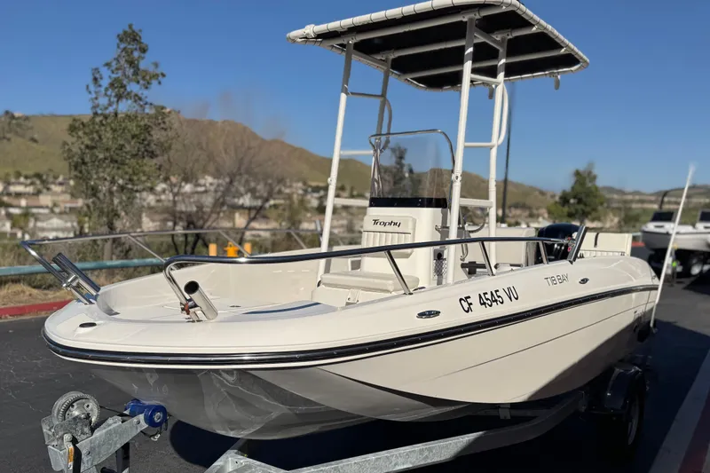 Slide: The Image of 2022 Trophy T18 boat on trailer, parked outdoors with scenic background. - 3