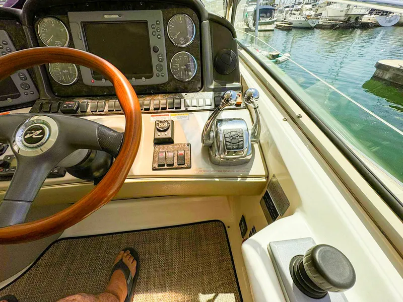 Slide: The Image of 2008 Sea Ray Sundancer helm with wooden steering wheel and control panel, docked at marina. - 22