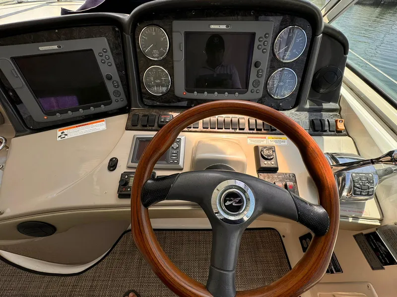 Slide: The Image of 2008 Sea Ray Sundancer helm with wooden steering wheel and navigation controls. - 28