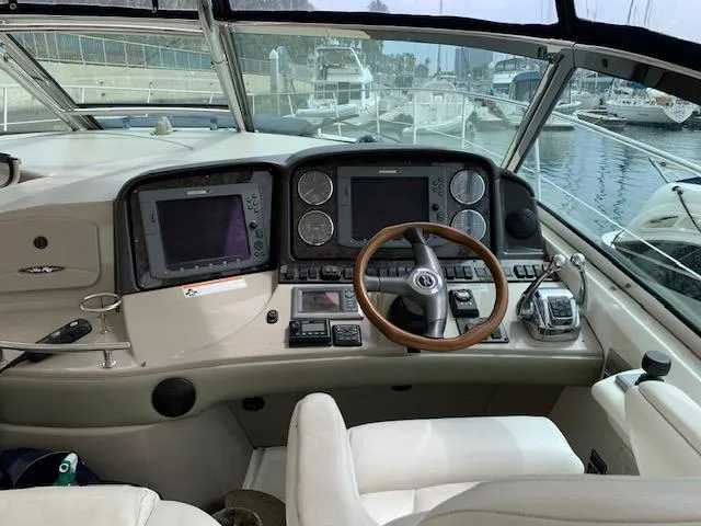 Slide: The Image of 2008 Sea Ray Sundancer helm with dual displays and wooden steering wheel at marina. - 38