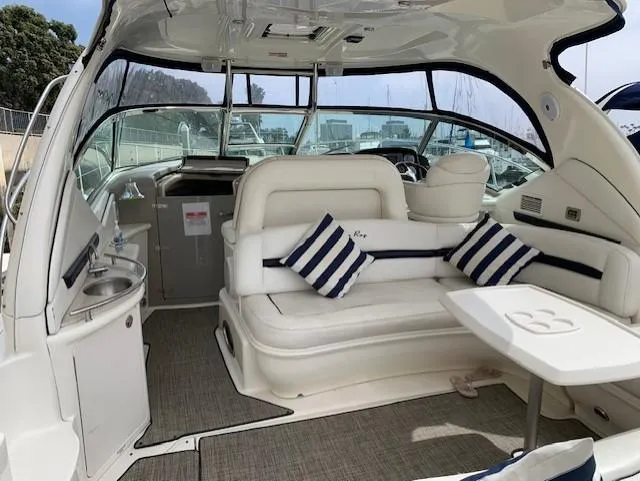 Slide: The Image of 2008 Sea Ray Sundancer interior with white seating, striped pillows, and a small table. - 41