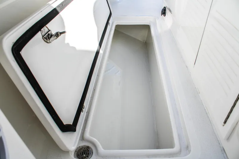 Slide: The Image of Open storage compartment on 2026 Invicta 320 CC boat, showcasing interior space. - 10