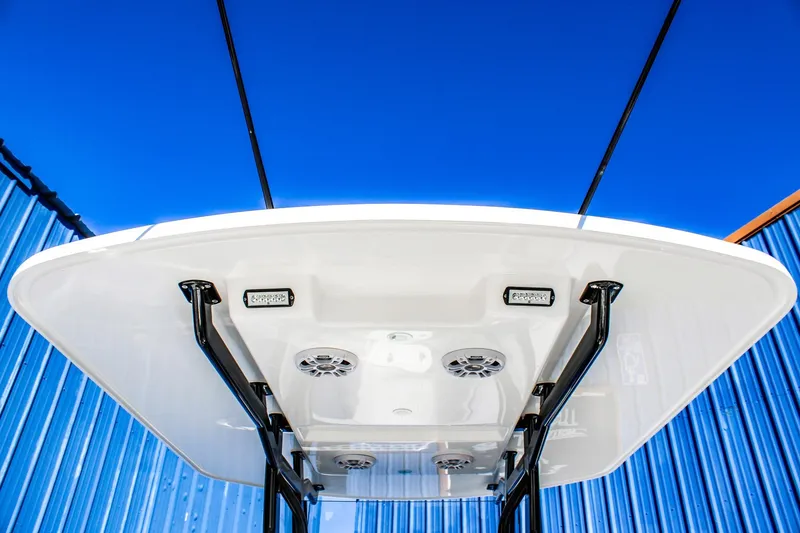 Slide: The Image of 2026 Invicta 320 CC boat canopy with speakers and lights against blue sky. - 7