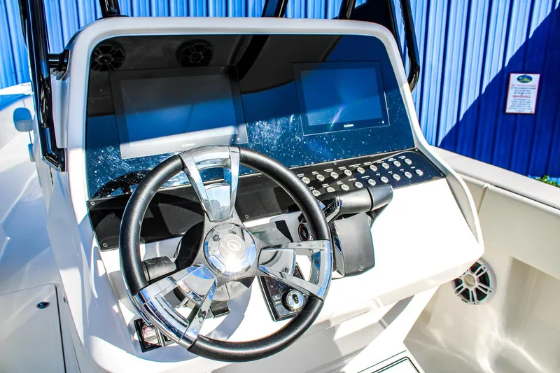 Slide: The Image of Steering console of 2026 Invicta 320 CC boat with dual screens and controls. - 8