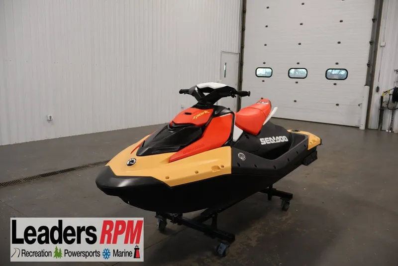 The Image of 2026 Sea-Doo Spark for 2 jet ski in showroom, featuring vibrant red and yellow design. - 2