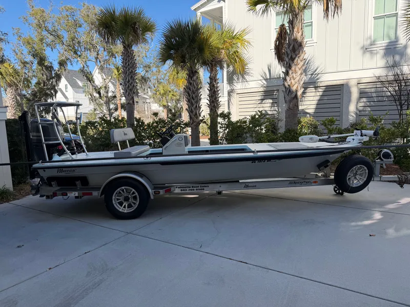 Slide: The Image of 2021 Maverick 17 HPX-S boat on trailer, surrounded by palm trees. - 2