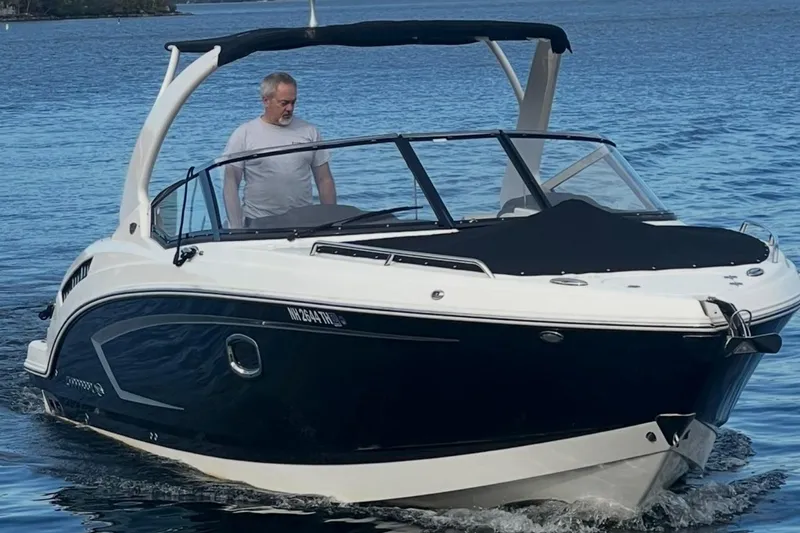 Slide: The Image of 2014 Chaparral 307 SSX boat on water with a person onboard, featuring sleek design. - 1