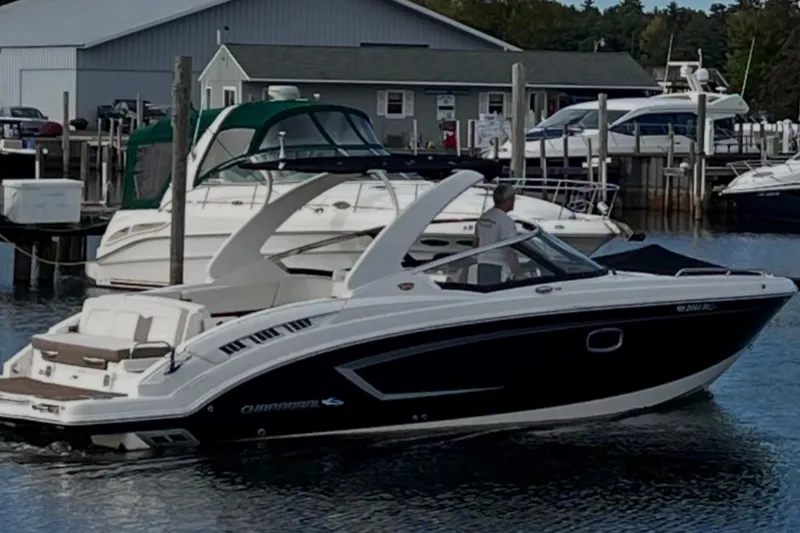Slide: The Image of 2014 Chaparral 307 SSX boat docked at a marina with other vessels. - 2