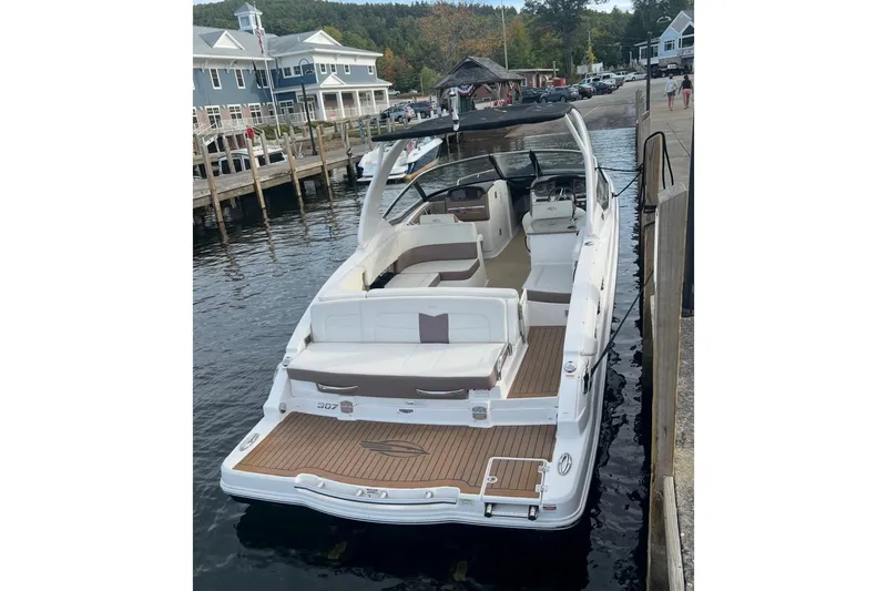 Slide: The Image of 2014 Chaparral 307 SSX boat docked at a marina, showcasing sleek design and spacious seating. - 3
