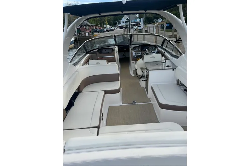 Slide: The Image of 2014 Chaparral 307 SSX boat interior with seating and helm, docked by the water. - 5