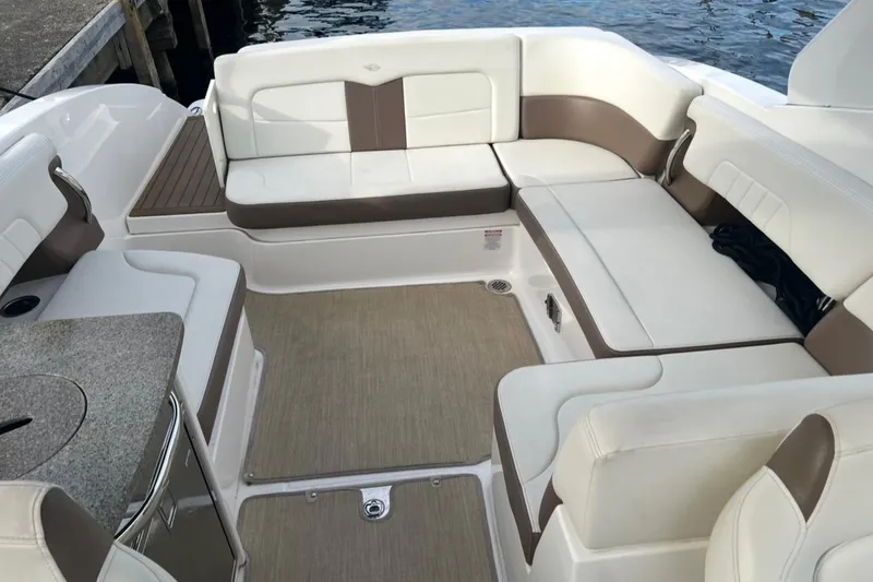 Slide: The Image of 2014 Chaparral 307 SSX boat interior with beige and white seating, docked by water. - 7