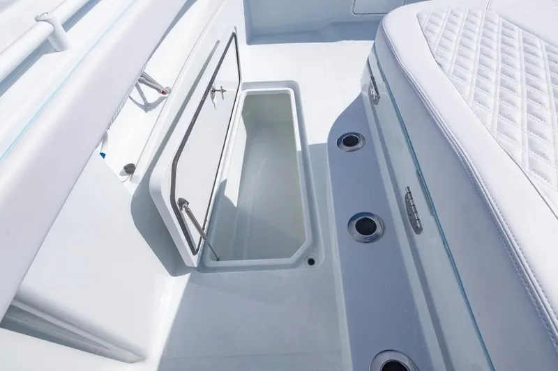 Slide: The Image of 2026 Invincible 33 Catamaran interior storage compartment with open hatch and cushioned seating. - 17