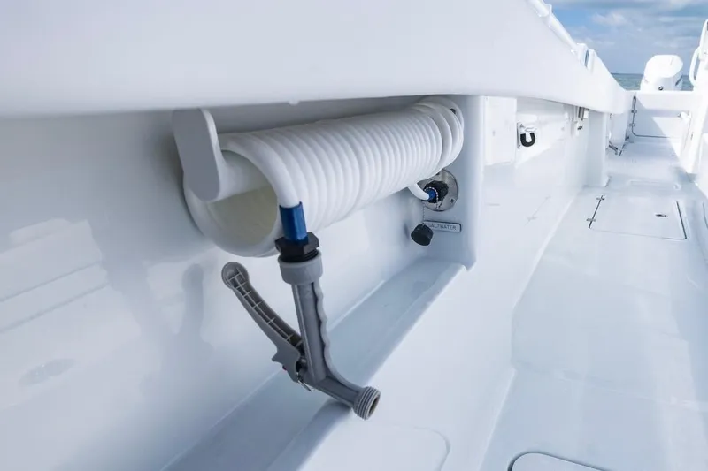 Slide: The Image of 2026 Invincible 33 Catamaran deck with coiled hose and saltwater outlet. - 19