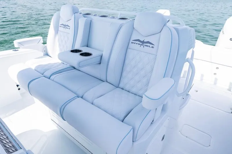 Slide: The Image of Luxurious seating on 2026 Invincible 33 Catamaran, featuring plush white upholstery and cup holders. - 25