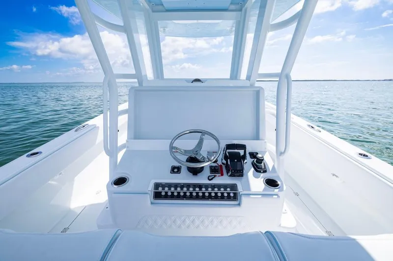 Slide: The Image of 2026 Invincible 33 Catamaran helm with ocean view, featuring modern controls and steering wheel. - 26