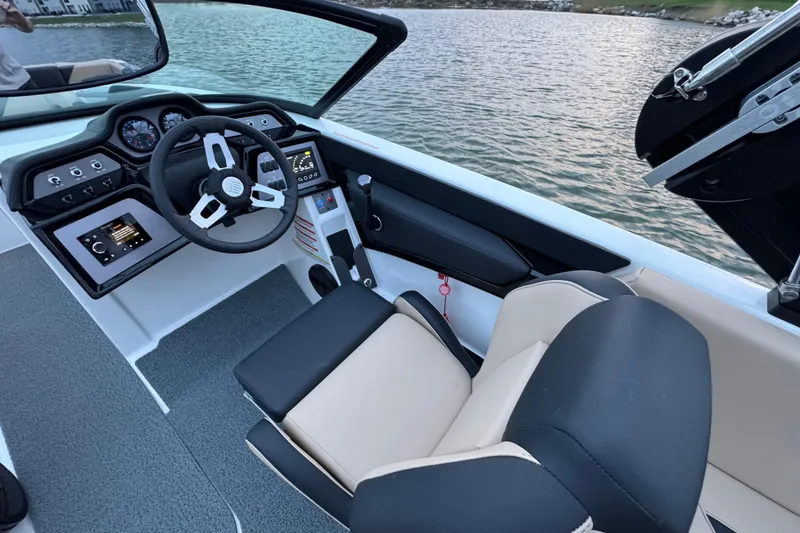 Slide: The Image of 2023 MasterCraft NXT22 boat interior with modern dashboard and steering wheel on water. - 15
