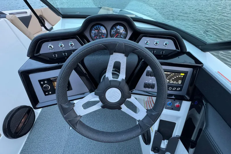 Slide: The Image of 2023 MasterCraft NXT22 boat dashboard with steering wheel and control panels. - 16